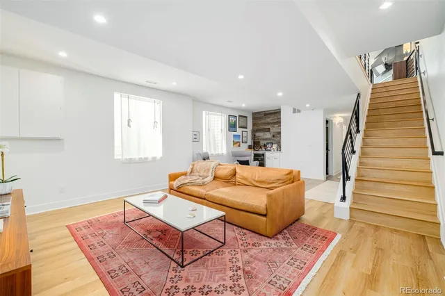 a living room with furniture and a wooden floor