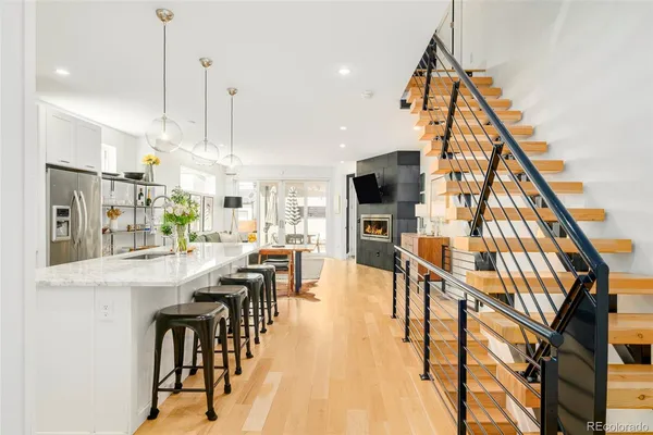 a view of dining room and livingroom with furniture wooden floor kitchen view and a chandelier