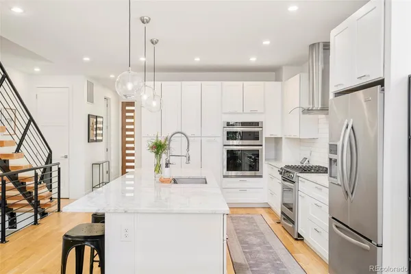 a kitchen with kitchen island a counter top space appliances and cabinets