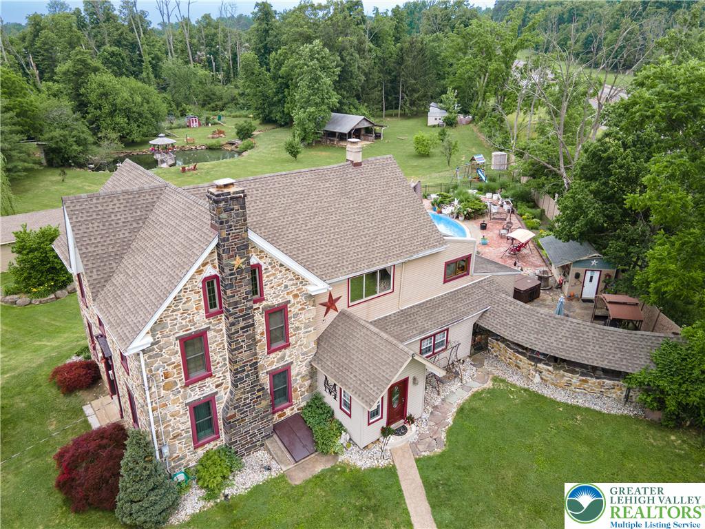 2485 Hieter Road Quakertown, PA 18951 - Photo 91 of 97 An aerial perspective reveals a charming stone-clad home with extensive grounds, featuring a tranquil pond, private pool, and mature trees.