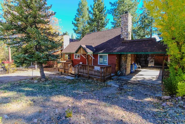 a view of a house with a yard and large tree