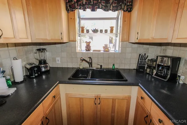 a kitchen with granite countertop a sink stove and cabinets