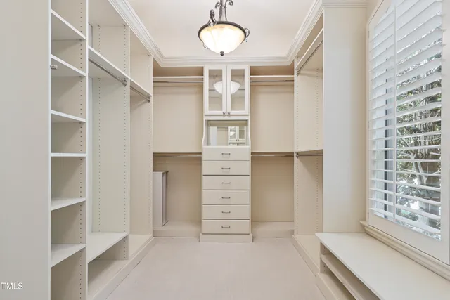 a front view of a house with a garden and trees