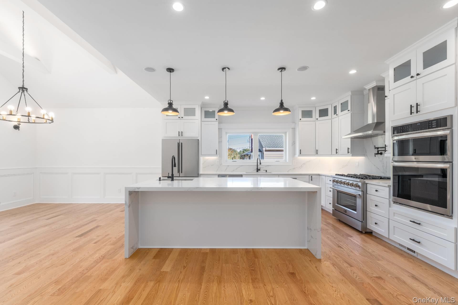 295 Grange Road Southold, NY 11971 - Photo 10 of 50 a kitchen with stainless steel appliances granite countertop a sink a stove and a wooden floors