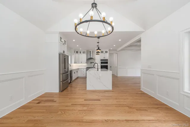 a large kitchen with stainless steel appliances kitchen island a large island in it