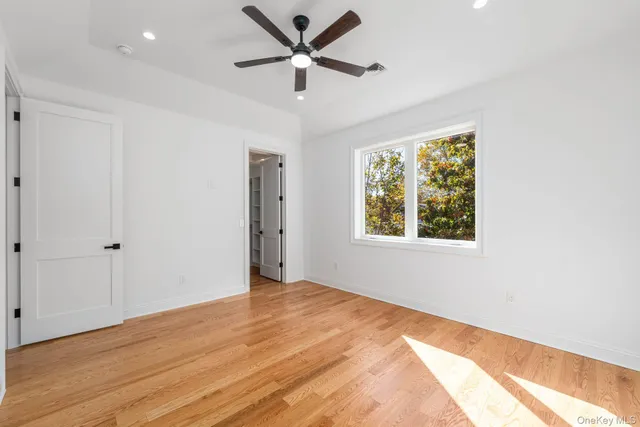 an empty room with a window and a fan