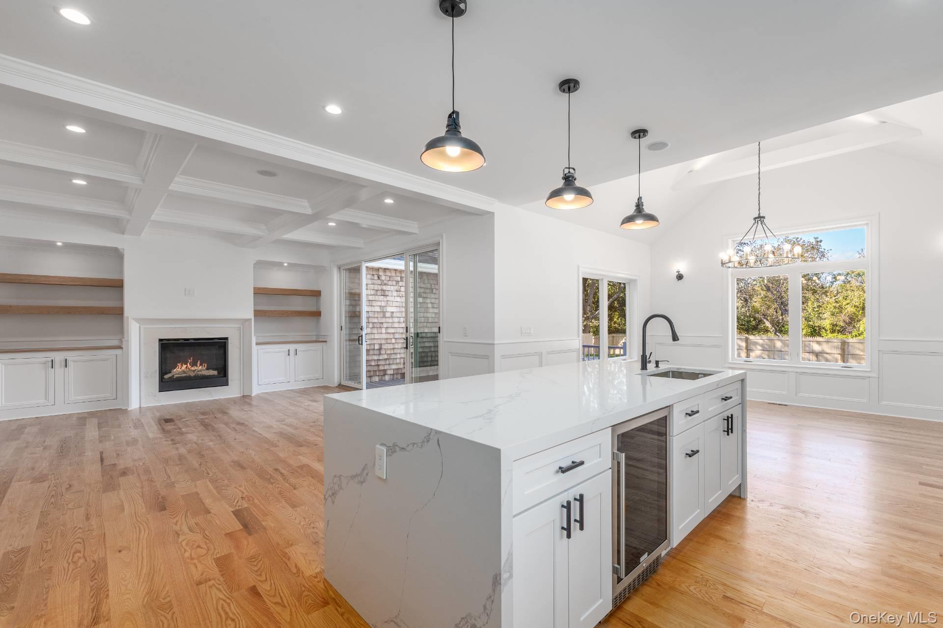 295 Grange Road Southold, NY 11971 - Photo 50 of 50 a large white kitchen with a large island oven a stove a sink a chimney and a fireplace