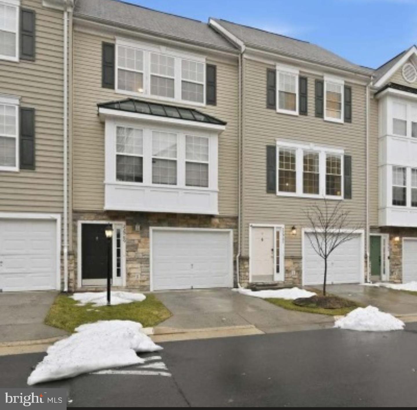 22987 Fontwell Square Sterling, VA 20166 - Photo 1 of 2 a front view of a house with a yard and a garage