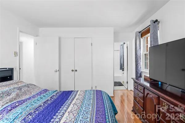 a bedroom with a bed and a flat screen tv