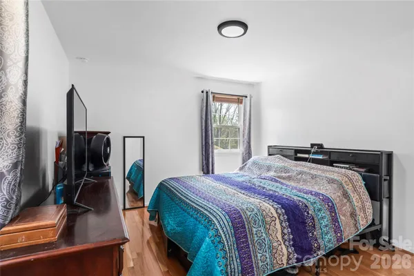 a bedroom with a bed and a flat tv screen on the dresser