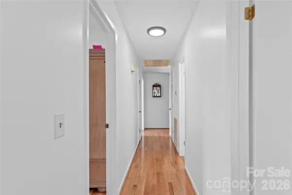 a view of a hallway with wooden floor and closet