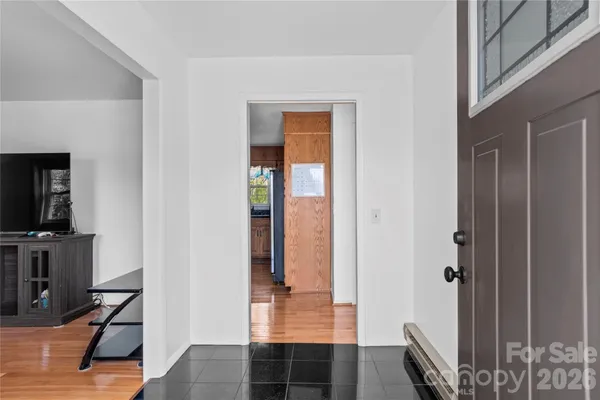 a view of a hallway with furniture and wooden floor