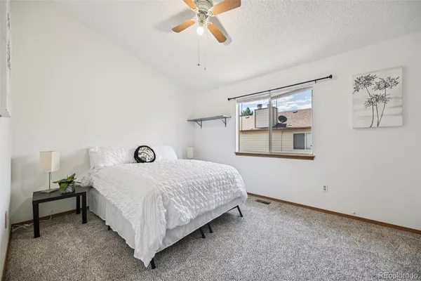 a bedroom with a bed and a ceiling fan