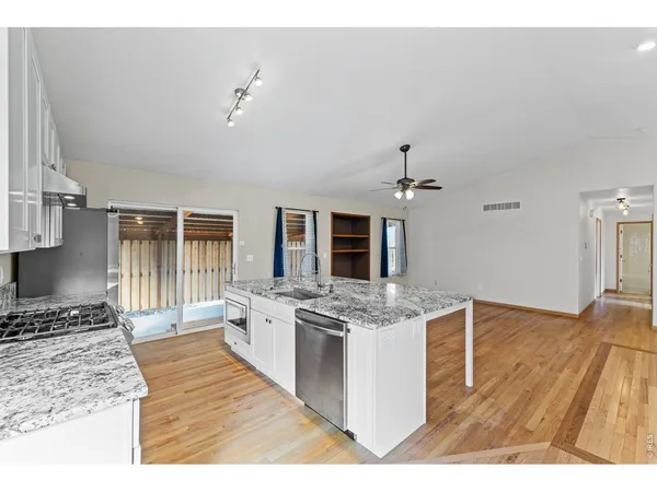 a kitchen with stainless steel appliances granite countertop a stove oven and a refrigerator with white cabinets