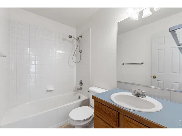 a bathroom with a granite countertop sink mirror toilet and bathtub
