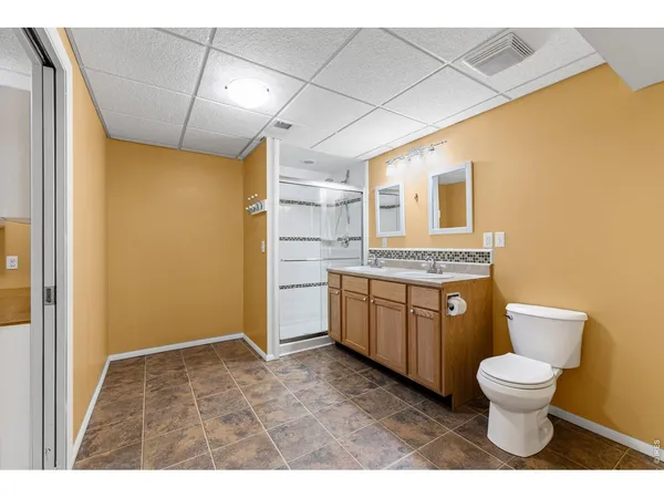 a bathroom with a granite countertop toilet sink and mirror