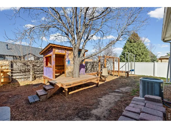 a backyard of a house with wooden floor barbeque oven and outdoor seating