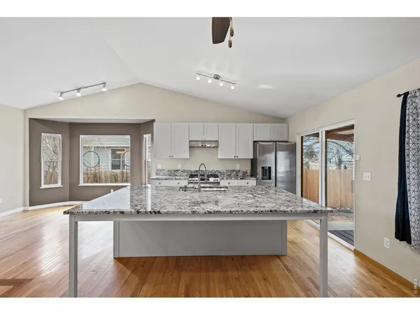 a view of living room and kitchen with wooden floor