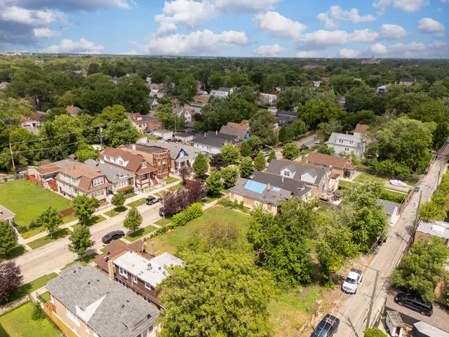 an aerial view of residential houses with outdoor space and trees