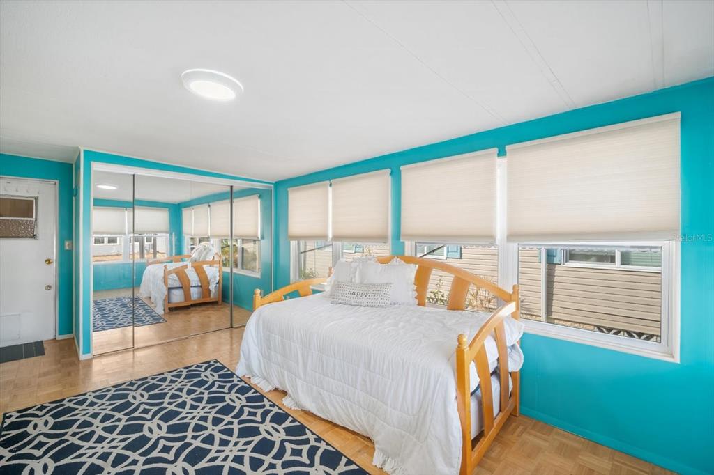 5619 Bayshore Road, Unit 417 Palmetto, FL 34221 - Photo 6 of 36 a bedroom with a bed and glass door