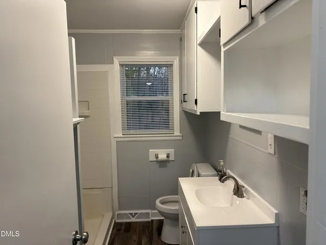 a bathroom with a sink a toilet and shower