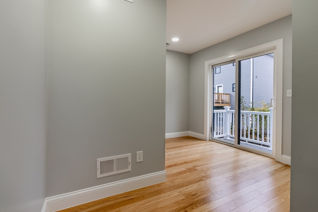 219 Earle Street, Unit 3 Fall River, MA 02723 - Photo 12 of 27 an empty room with wooden floor and a window