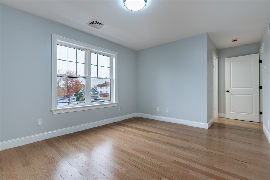 219 Earle Street, Unit 3 Fall River, MA 02723 - Photo 16 of 27 a view of an empty room with wooden floor and a window