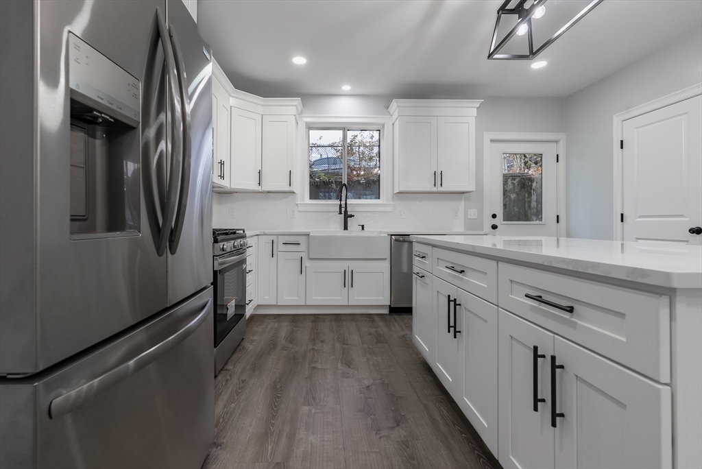 219 Earle Street, Unit 3 Fall River, MA 02723 - Photo 6 of 27 a kitchen with white cabinets stainless steel appliances a sink and a window