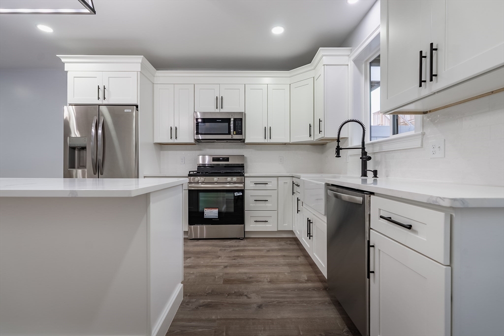 219 Earle Street, Unit 3 Fall River, MA 02723 - Photo 7 of 27 a kitchen with kitchen island a sink stainless steel appliances and cabinets