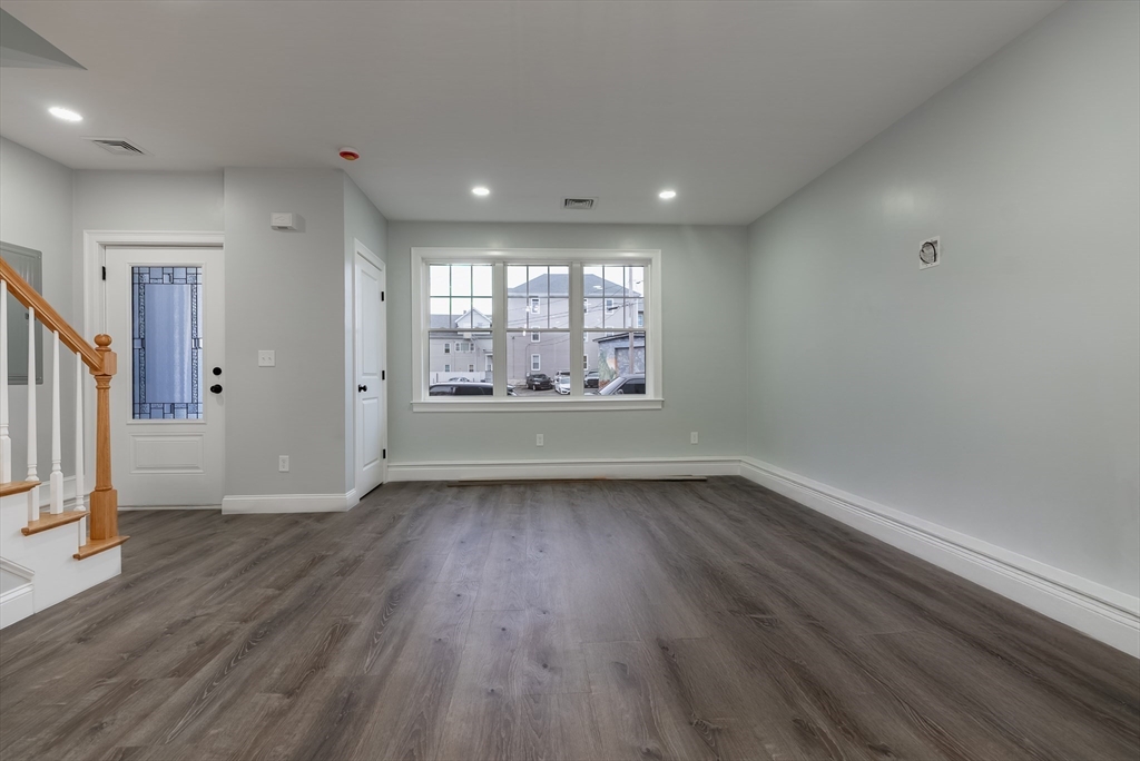 219 Earle Street, Unit 3 Fall River, MA 02723 - Photo 8 of 27 an empty room with wooden floor and windows