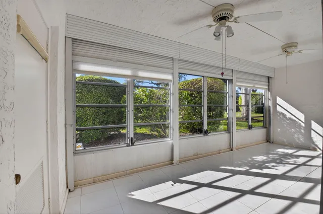 a view of a house with potted plants and palm trees