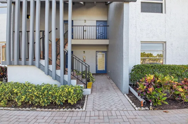 an empty room with chandelier fan and windows