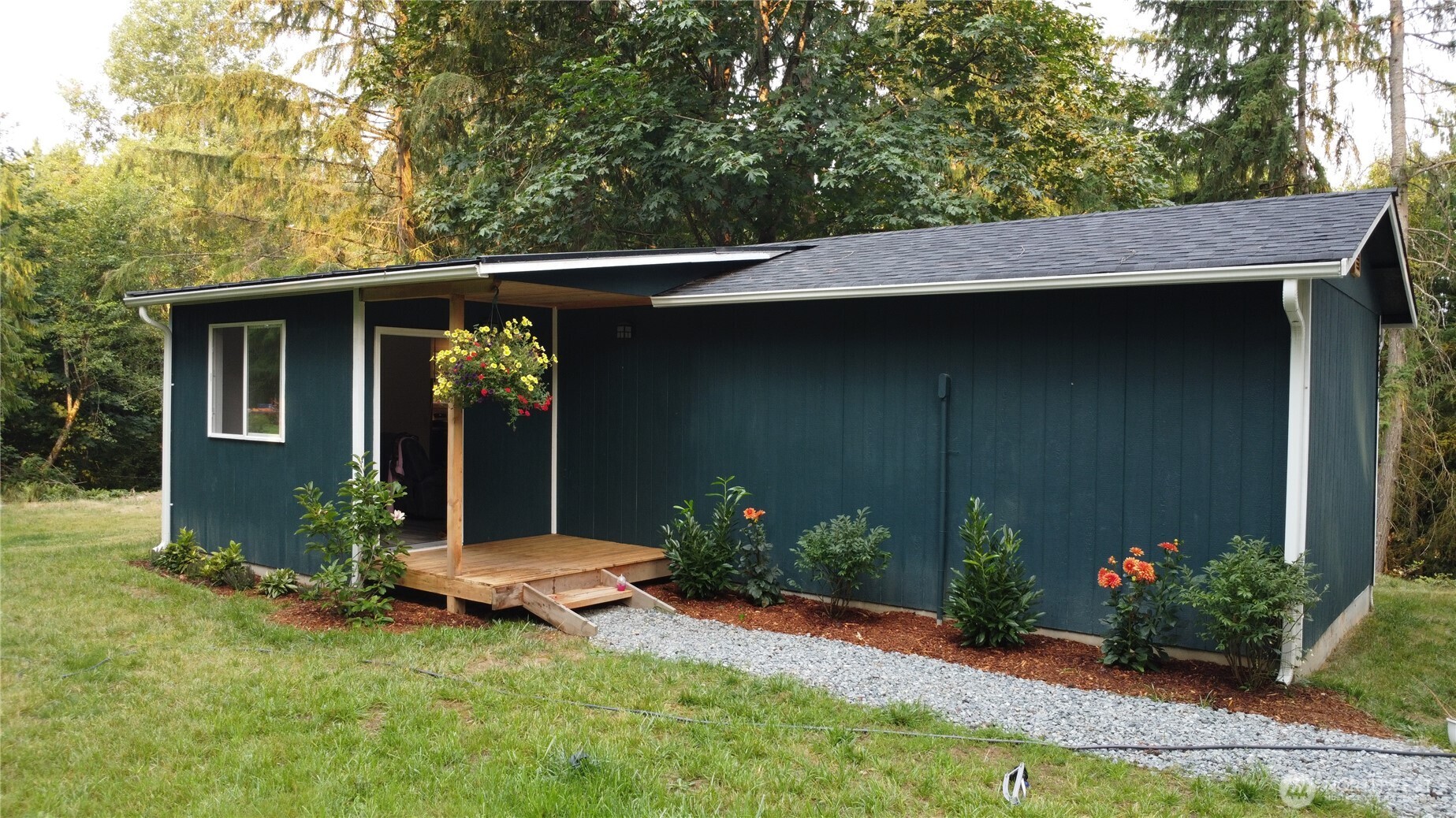 a backyard of a house with table and chairs potted plants