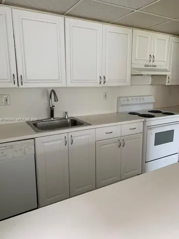 a kitchen with white cabinets granite counter tops and a stove