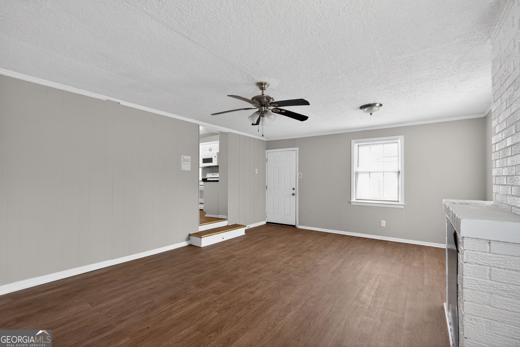 1883 Clarke Lane Decatur, GA 30035 - Photo 11 of 32 an empty room with wooden floor chandelier fan and windows