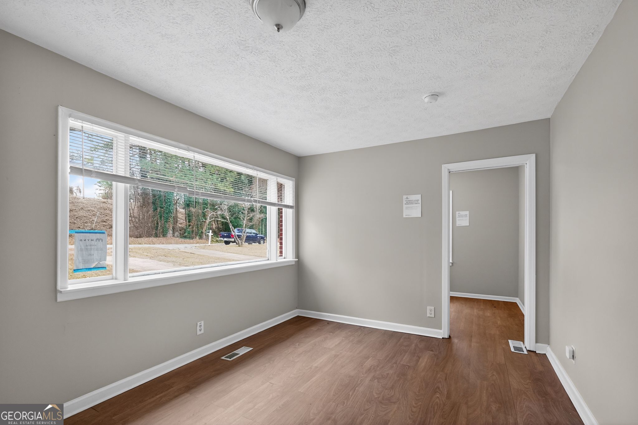 1883 Clarke Lane Decatur, GA 30035 - Photo 14 of 32 an empty room with wooden floor and windows