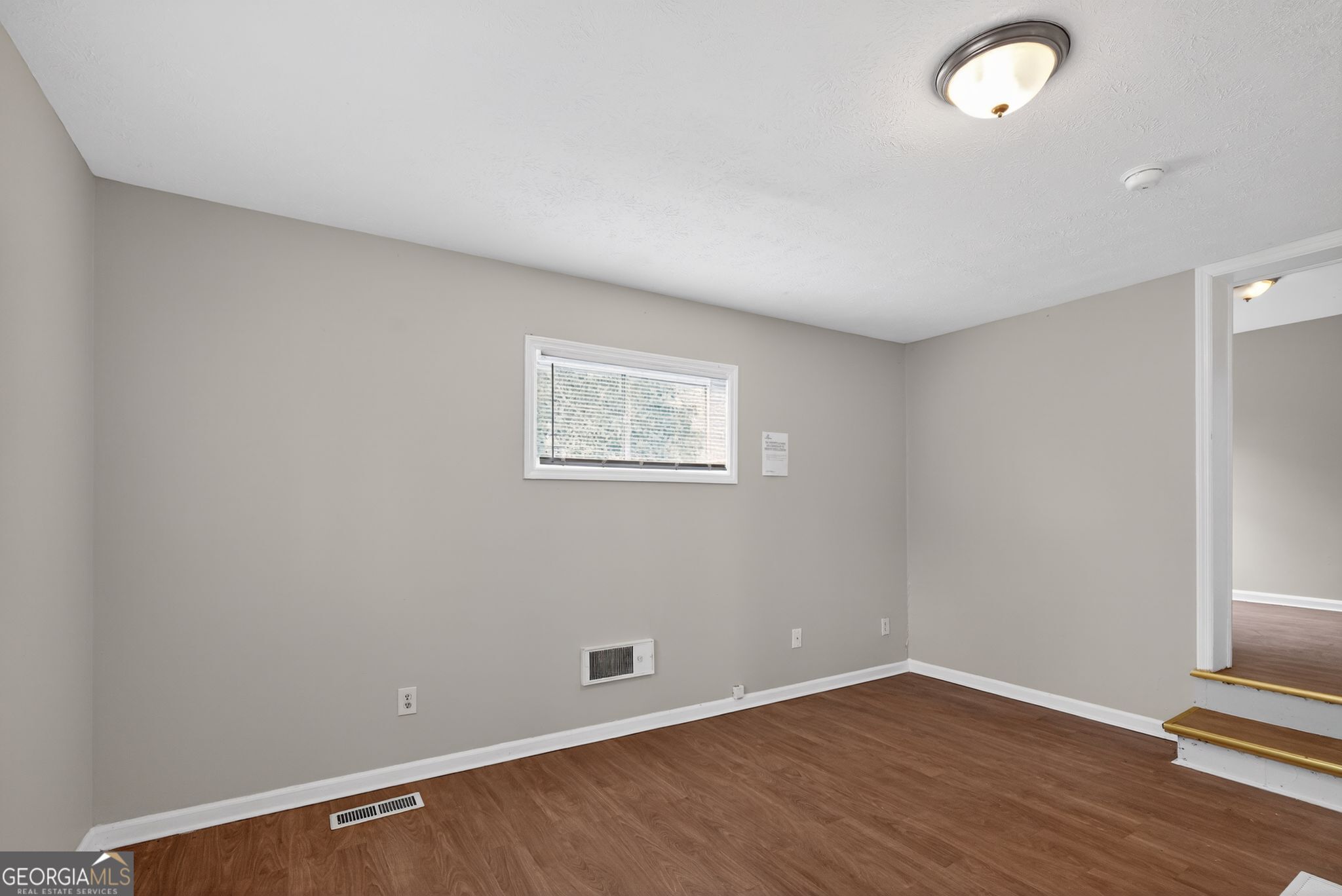 1883 Clarke Lane Decatur, GA 30035 - Photo 16 of 32 a view of an empty room with wooden floor and a window