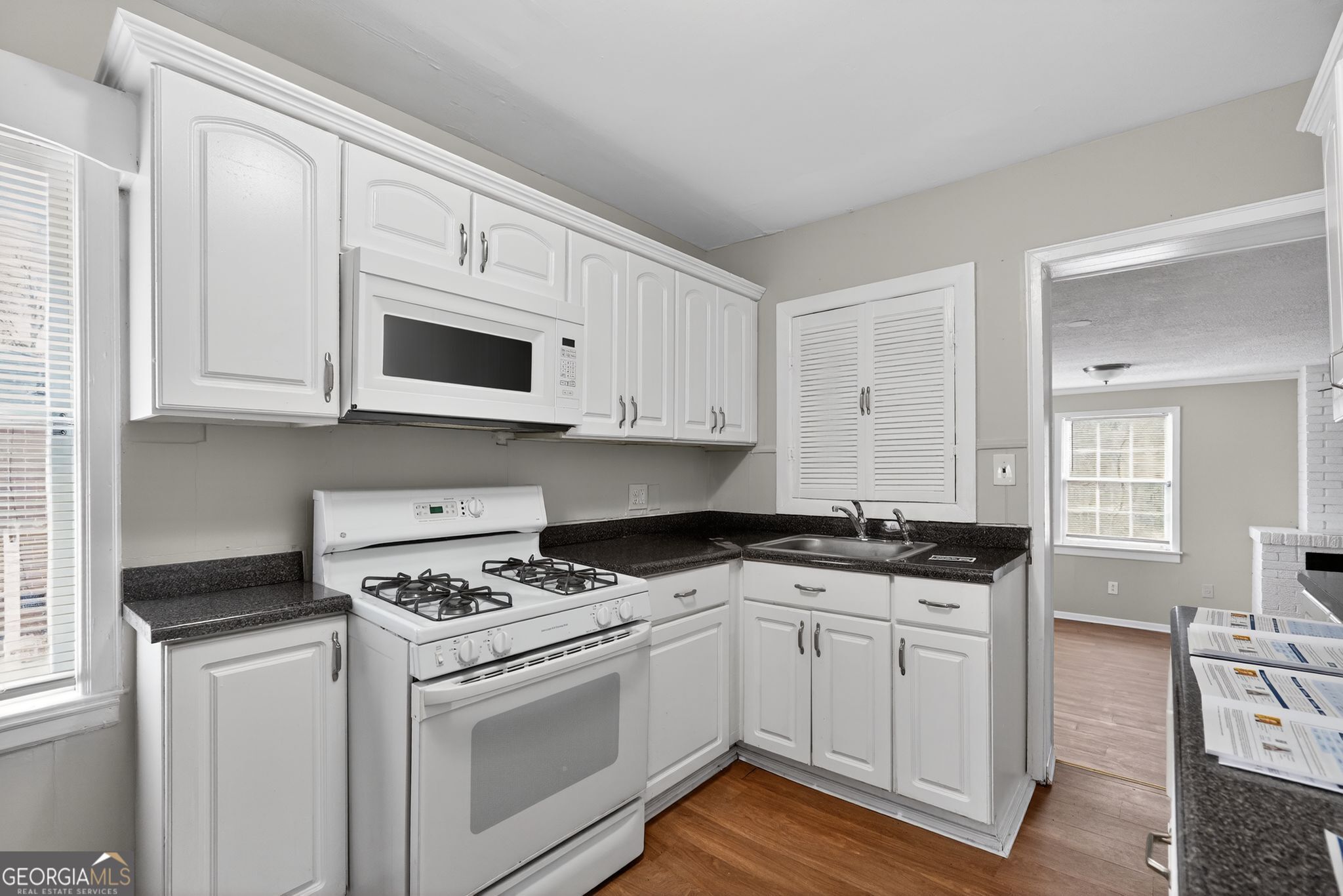 1883 Clarke Lane Decatur, GA 30035 - Photo 21 of 32 a kitchen with granite countertop white cabinets and white appliances