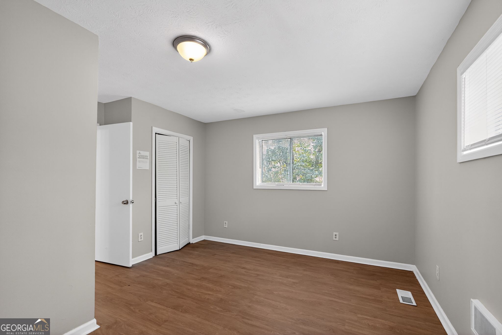 1883 Clarke Lane Decatur, GA 30035 - Photo 22 of 32 an empty room with wooden floor and windows