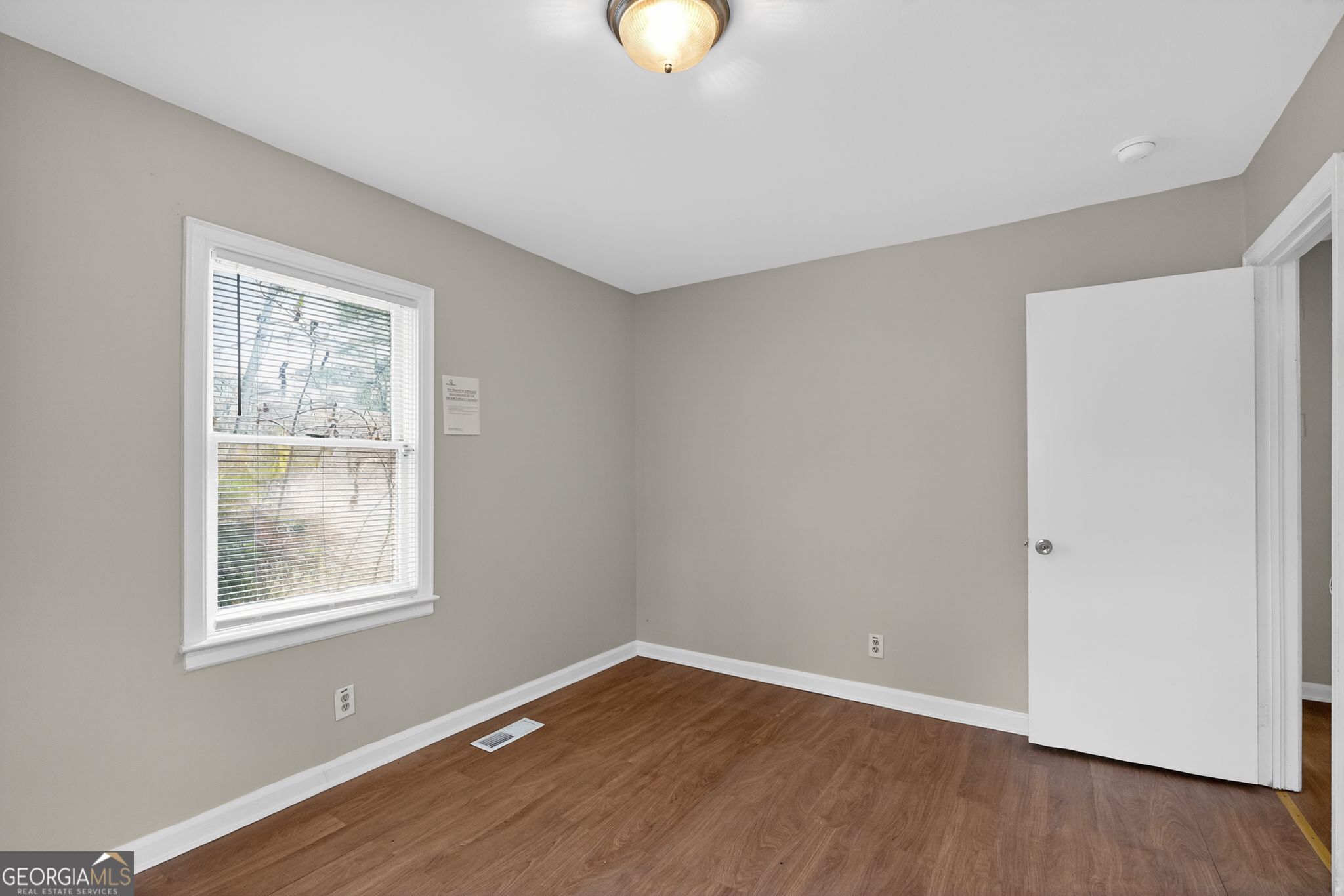 1883 Clarke Lane Decatur, GA 30035 - Photo 24 of 32 a view of an empty room with window and wooden floor