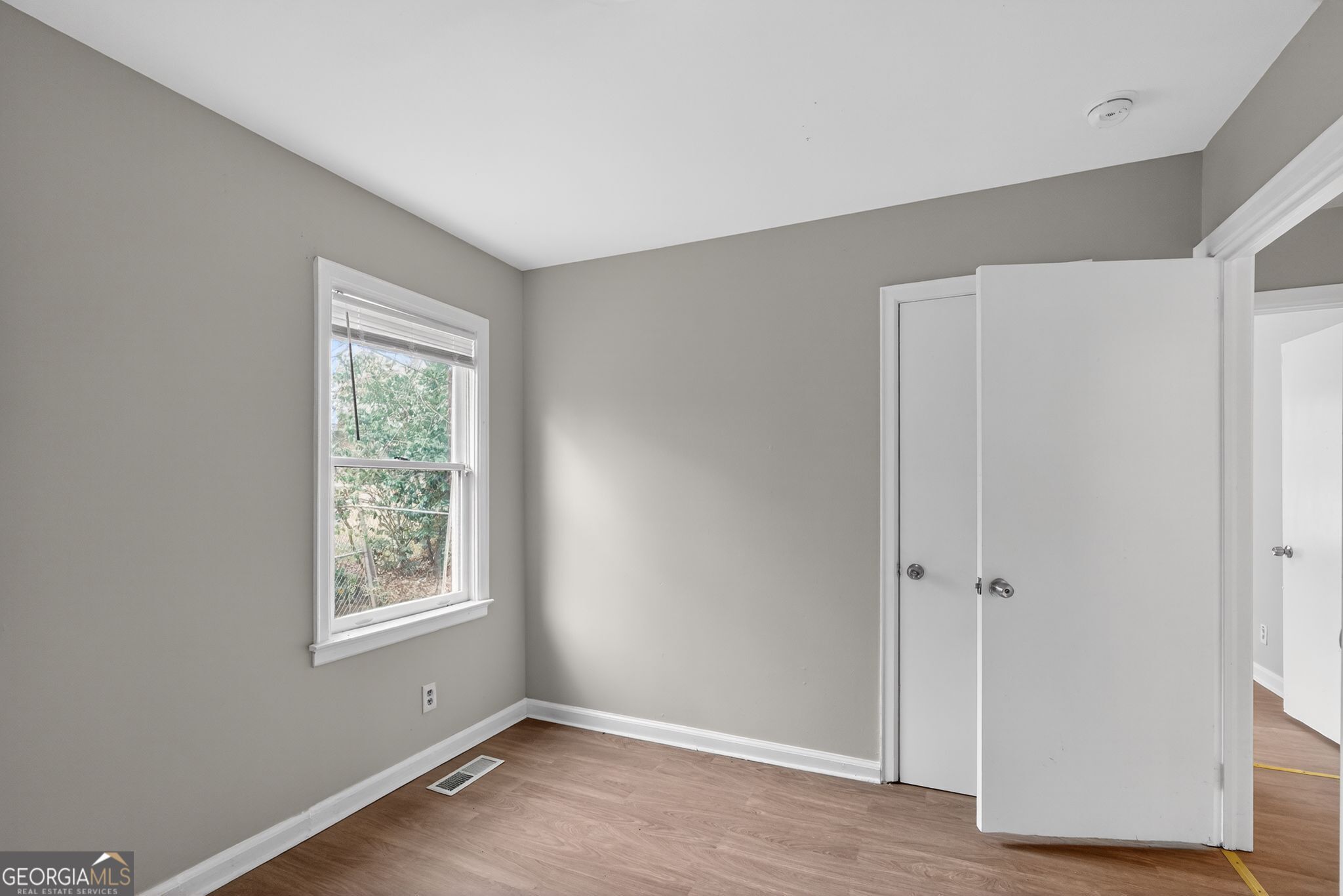 1883 Clarke Lane Decatur, GA 30035 - Photo 26 of 32 an empty room with wooden floor and a window