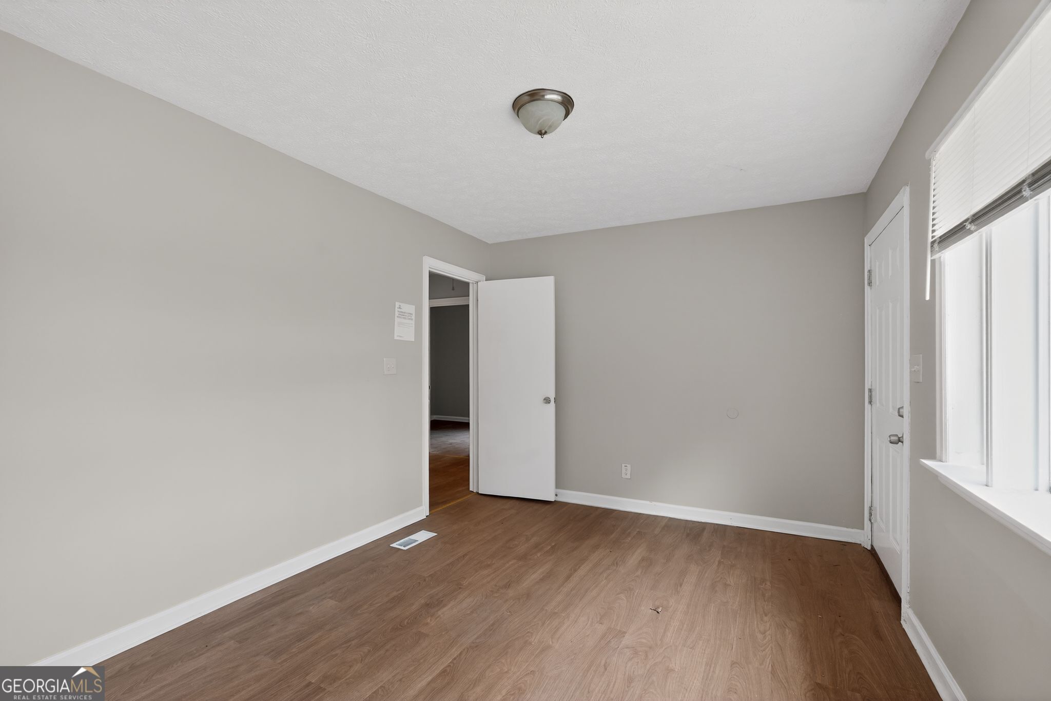 1883 Clarke Lane Decatur, GA 30035 - Photo 27 of 32 a view of an empty room with wooden floor and a window