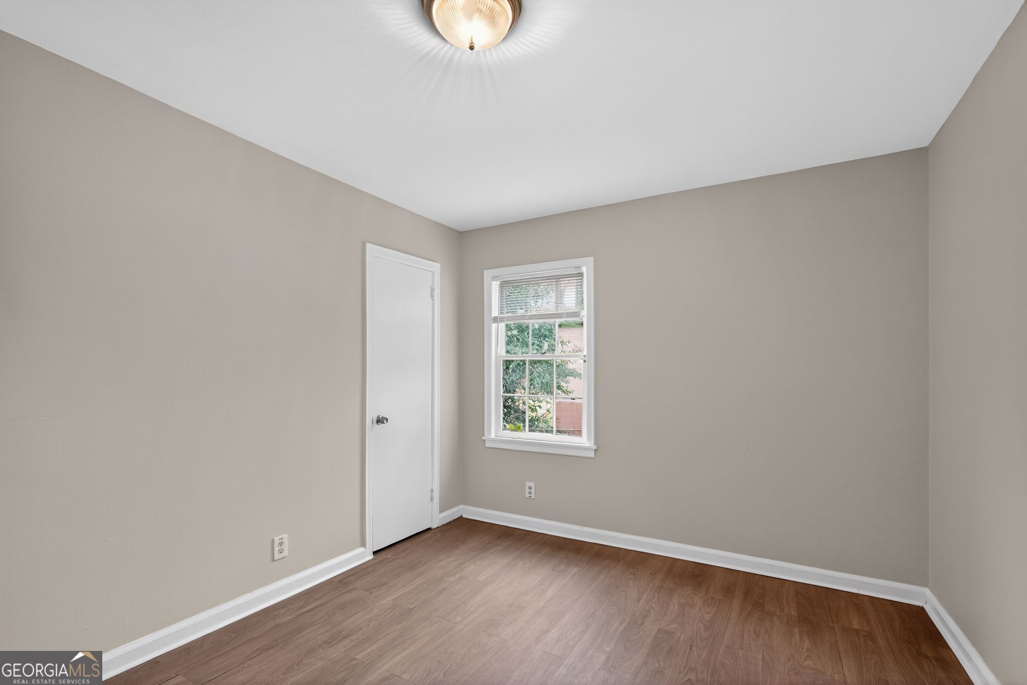 1883 Clarke Lane Decatur, GA 30035 - Photo 4 of 32 an empty room with wooden floor and windows