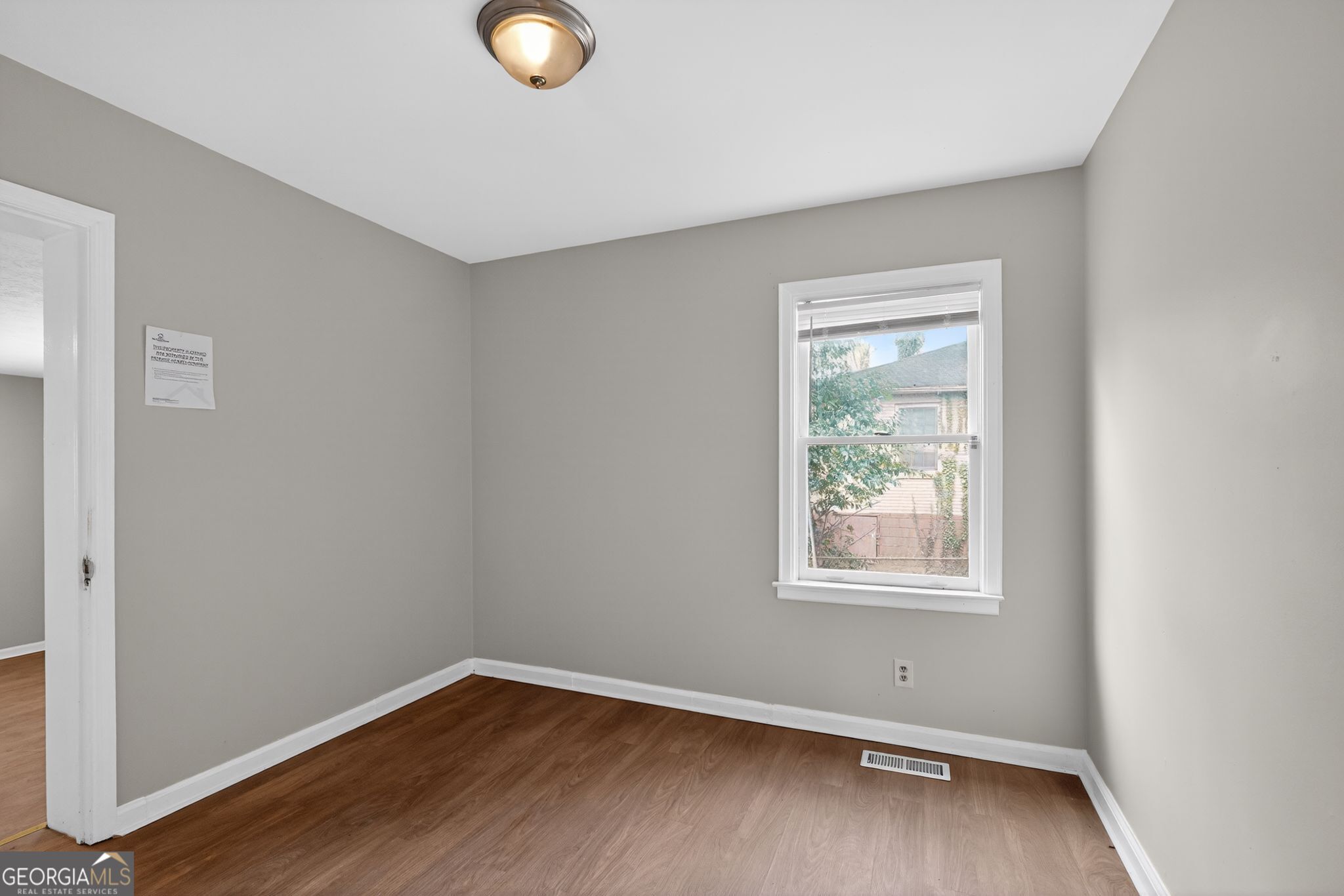 1883 Clarke Lane Decatur, GA 30035 - Photo 6 of 32 an empty room with wooden floor and windows