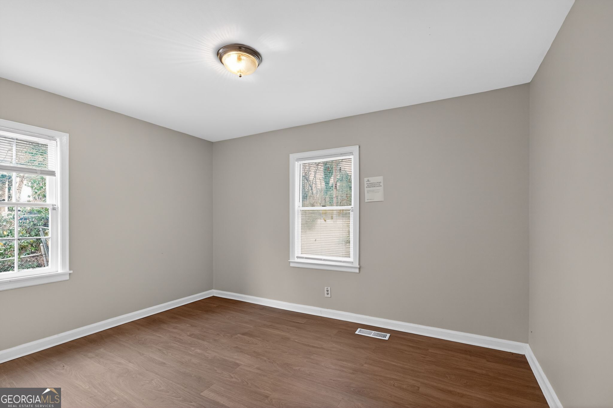 1883 Clarke Lane Decatur, GA 30035 - Photo 9 of 32 an empty room with wooden floor and windows