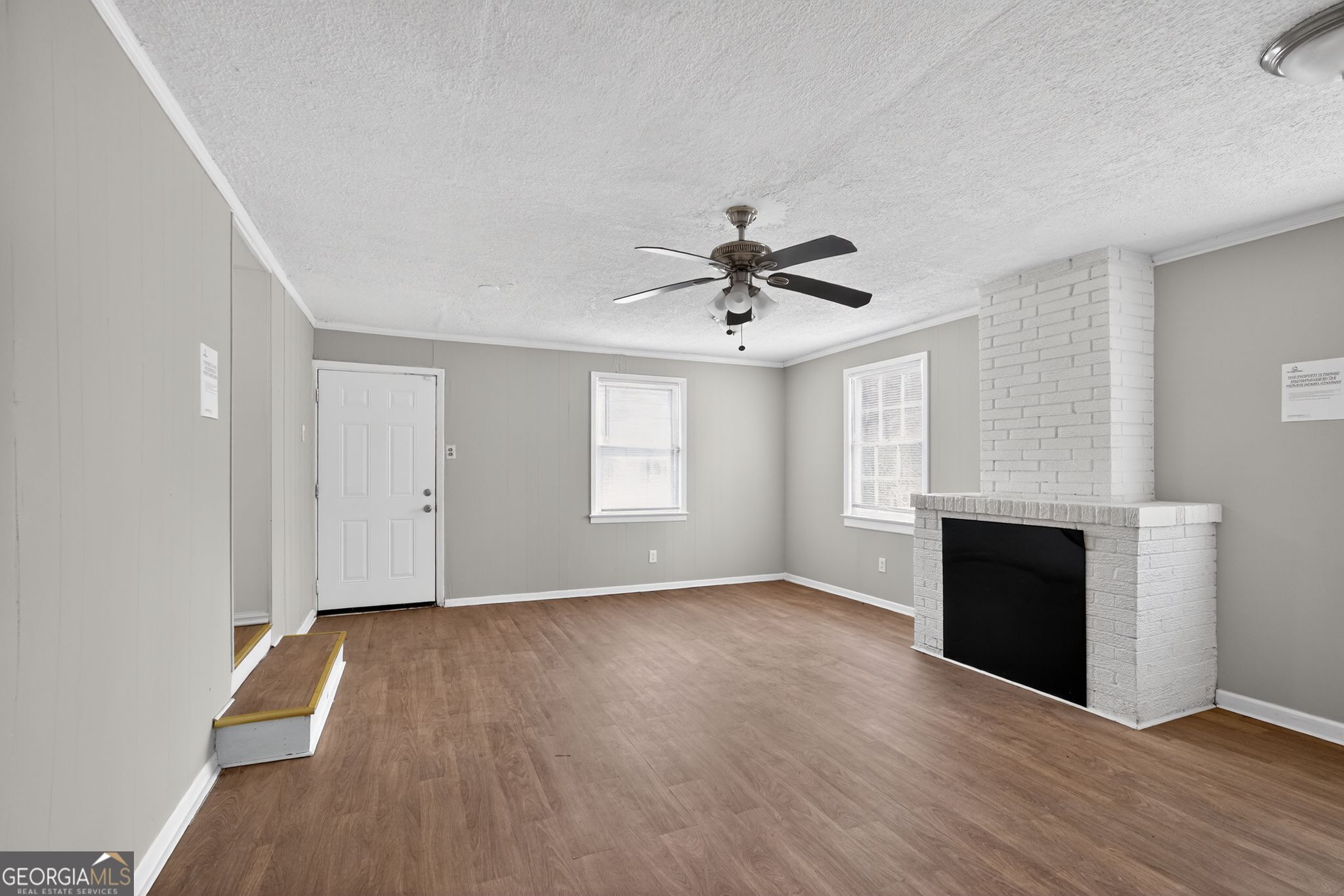1883 Clarke Lane Decatur, GA 30035 - Photo 10 of 32 a view of an empty room with wooden floor and a fireplace