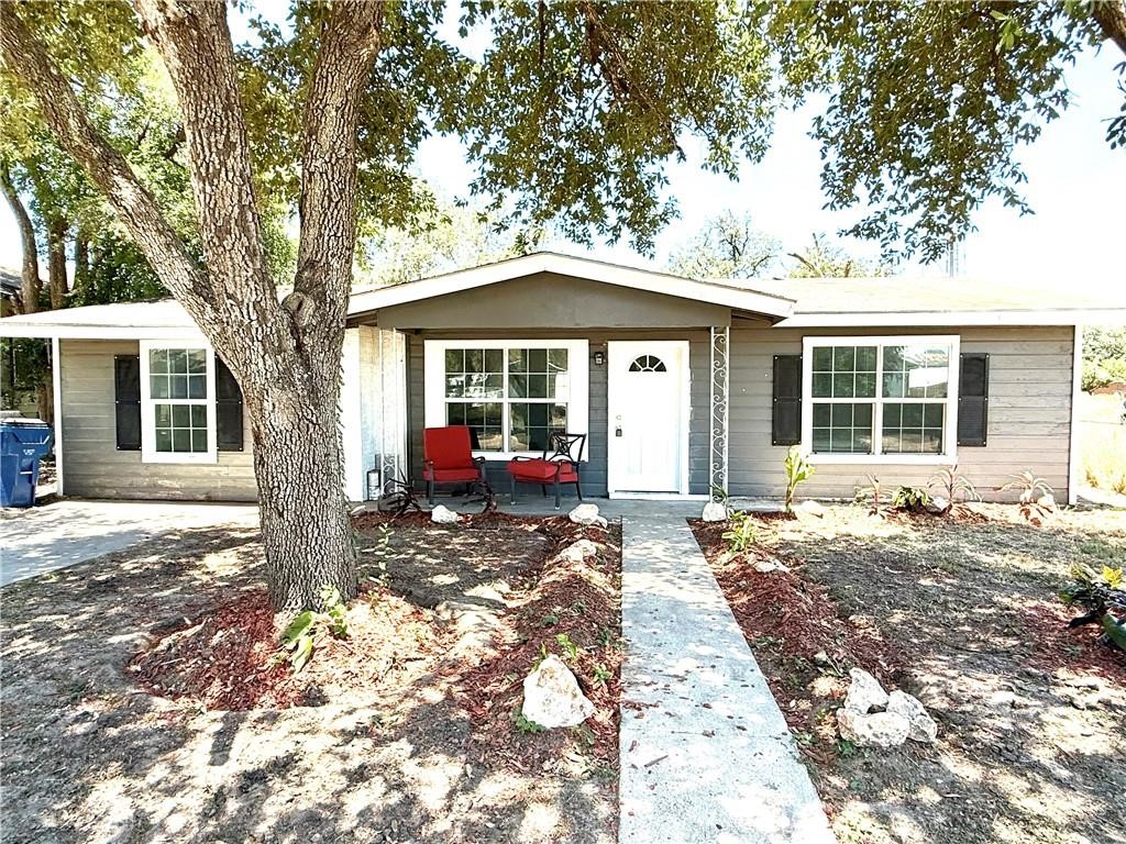 a view of a house with a tree in the backyard