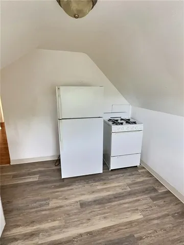 a utility room with wooden floor washer and dryer