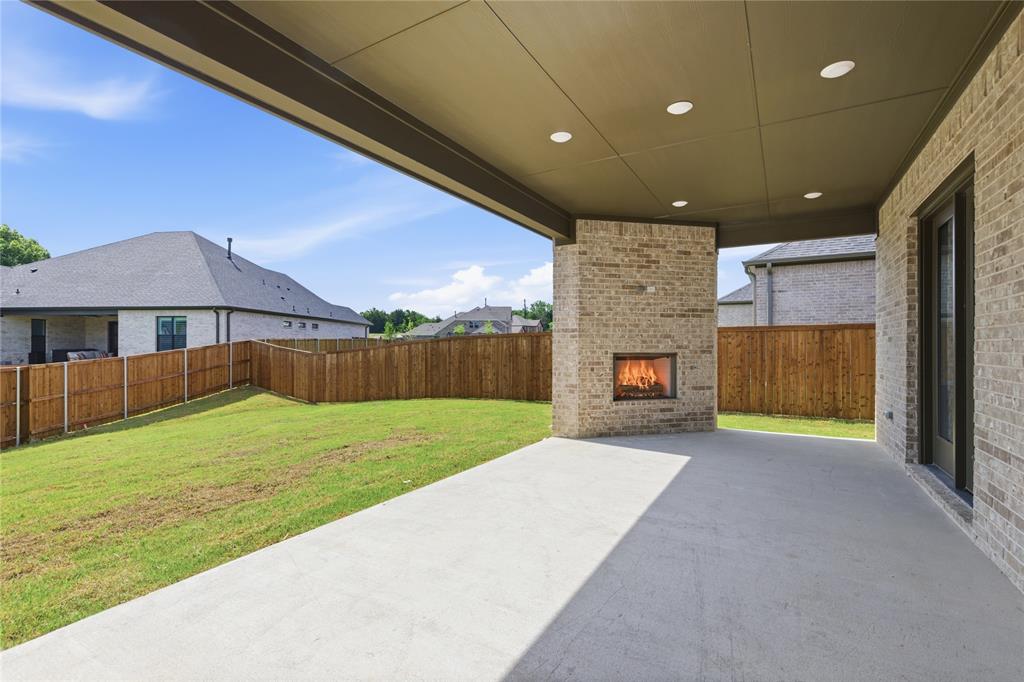 709 Anne Road Van Alstyne, TX 75495 - Photo 25 of 28 Covered patio featuring a built-in brick fireplace, concrete flooring, recessed lighting, and a sliding glass door