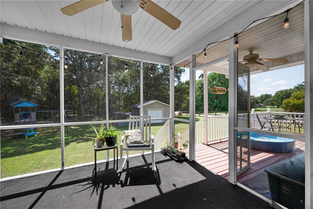 247 Clardy Road Pelzer, SC 29669 - Photo 20 of 34 An inviting screened porch overlooks a spacious grassy yard and adjoining open deck space.